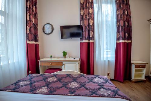 a bedroom with a bed and a desk and a clock at Ana Boutique in Alba Iulia