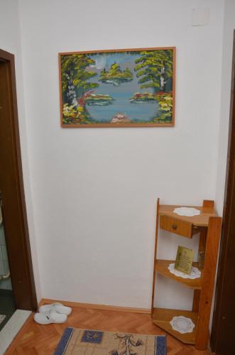 a painting hanging on a wall next to a shelf at Apartment Elmari in Prilep