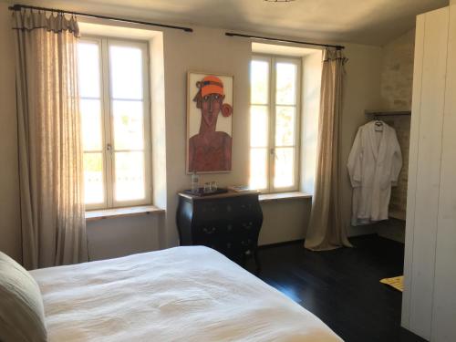 um quarto com uma cama e uma pintura de um homem em Les Clés d'Ars em Ars-en-Ré