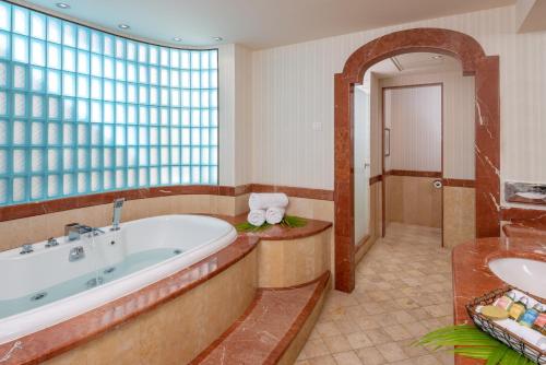 a large bathroom with a tub and a sink at Herods Boutique Eilat a Premium collection by Fattal Hotels in Eilat