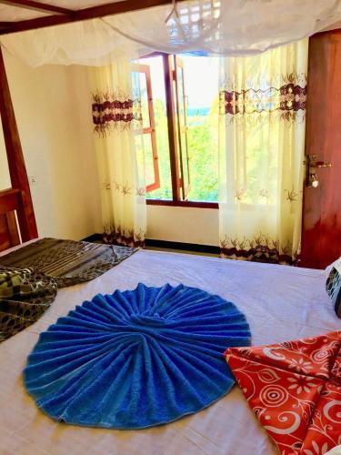 a blue umbrella on a bed in a room at Mahee house in Hiriketiya