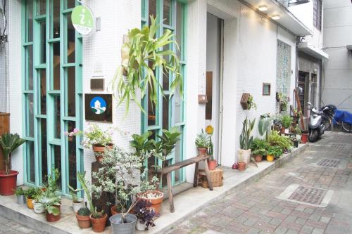 台南的住宿－Jimu's Holiday Home 吉姆俱樂部-台南包棟寵物友善民宿，旁边是种盆栽植物的建筑