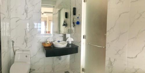 a white bathroom with a toilet and a sink at Hoang Yen Canary Hotel in Quy Nhon