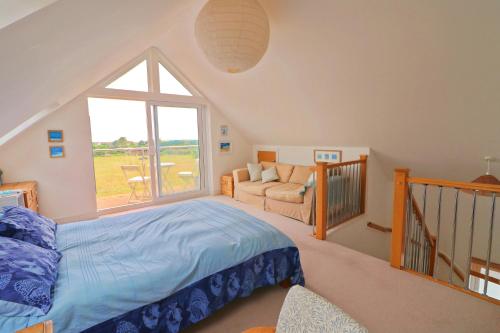 a bedroom with a bed and a large window at MODERN HOLIDAY HOME central St Merryn in Saint Merryn