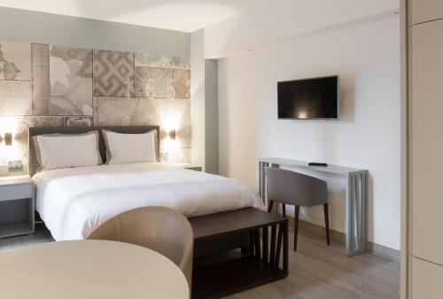 Habitación de hotel con cama y escritorio en The Residence Gare en Luxemburgo