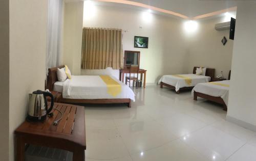 a hotel room with two beds and a table at Hoang Yen Canary Hotel in Quy Nhon