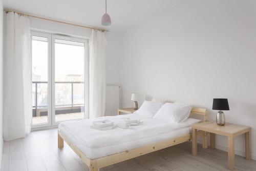 ポズナンにあるApartments Poznań Atal Maltaの白いベッドルーム(ベッド1台、窓付)
