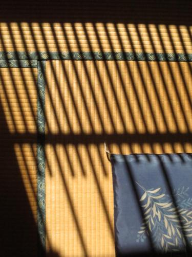 a shadow of a blind on a bed with a pillow at Shitanda in Takayama