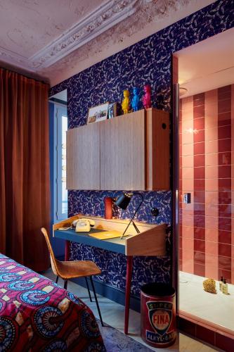 a room with a bed and a desk and a shower at 25hours Hotel Terminus Nord in Paris