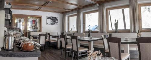 a dining room with tables and chairs and windows at Haus Tanja in Sölden