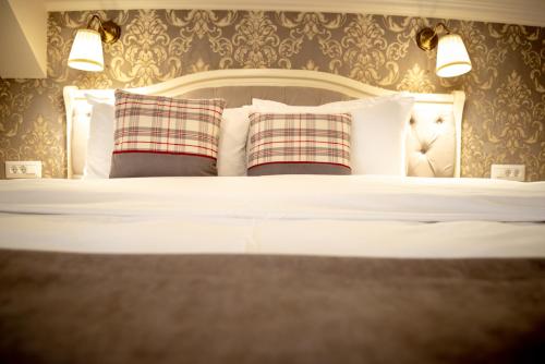 a bedroom with a white bed with two pillows at Ana Boutique in Alba Iulia