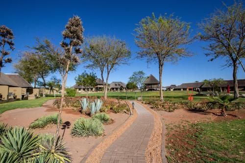 a walkway in a park with trees and plants at Lapa Lange Game Lodge in Mariental
