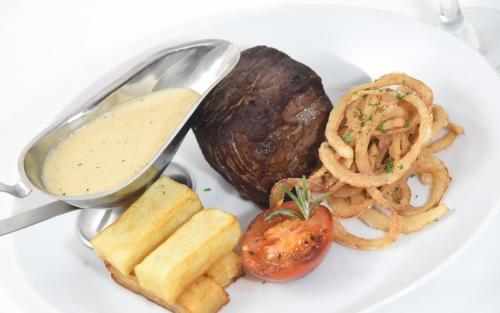 a plate of food with onion rings and a sauce at The Lodge Hotel in Coleraine