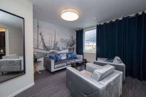 sala de estar con sofás y ventana grande en Svartisen Apartments, en Glomfjord