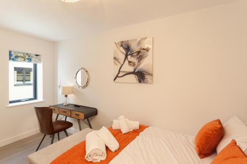 a bedroom with a bed and a desk with a mirror at 17 Woolacombe The Byron in Woolacombe