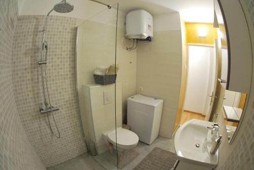 a bathroom with a shower and a toilet and a sink at Apartman Ružica in Makarska