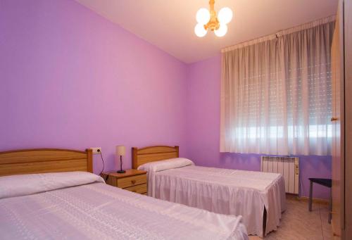 ブエウにあるPRIMERA LÍNEA DE PLAYAの紫色のベッドルーム(ベッド2台、窓付)