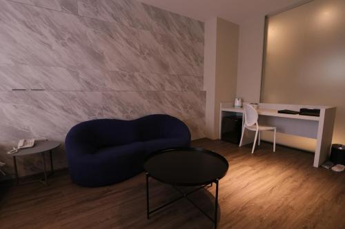 a living room with a blue chair and a table at Hotel Hesper HSR Taichung in Wuri