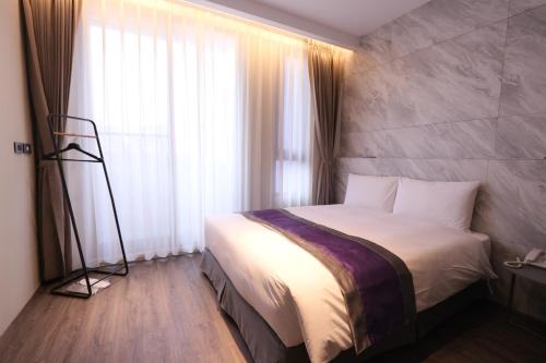 a bedroom with a bed and a large window at Hotel Hesper HSR Taichung in Wuri