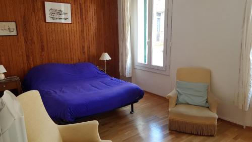 une chambre avec un lit, une chaise et une fenêtre dans l'établissement Rue sebastien spacious apartment close beach, à Banyuls-sur-Mer