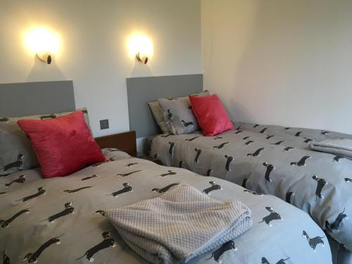 a bedroom with two beds with black and red pillows at Orchard Hideaway in Kelso