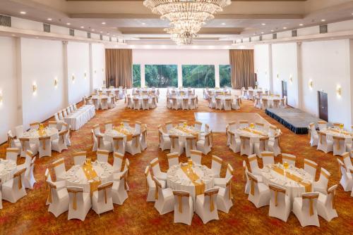 Un salón de banquetes con mesas y sillas blancas. en Citrus Waskaduwa, en Kalutara