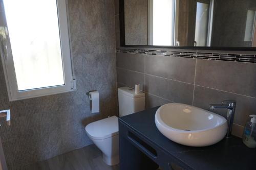 デニアにあるCosta de la Calmaのバスルーム(洗面台、トイレ、鏡付)
