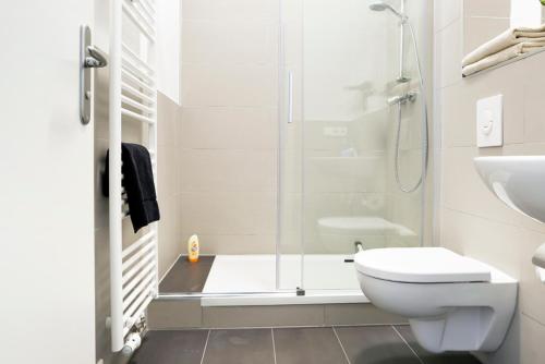 y baño con ducha, aseo y lavamanos. en SC 3 Cozy Family & Business Flair welcomes you - Rockchair Apartments, en Berlín