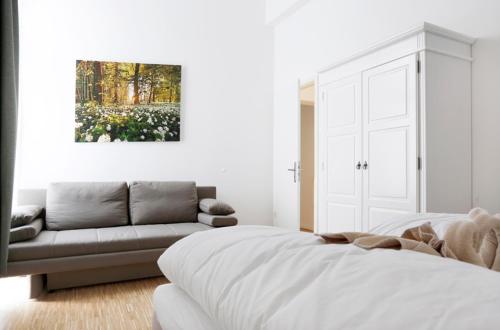 Habitación blanca con cama y sofá en SC 4 Cozy Family & Business Flair welcomes you - Rockchair Apartments en Berlín