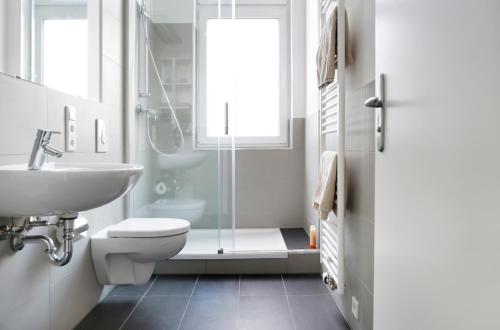 y baño con ducha, aseo y lavamanos. en SC 4 Cozy Family & Business Flair welcomes you - Rockchair Apartments en Berlín