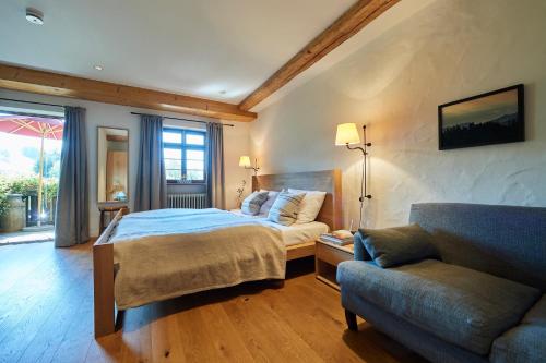 a bedroom with a bed and a couch at Hotel & Restaurant Linde in Münstertal