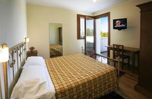 a bedroom with a bed and a desk and a television at Country House Letizia in Ca' di David