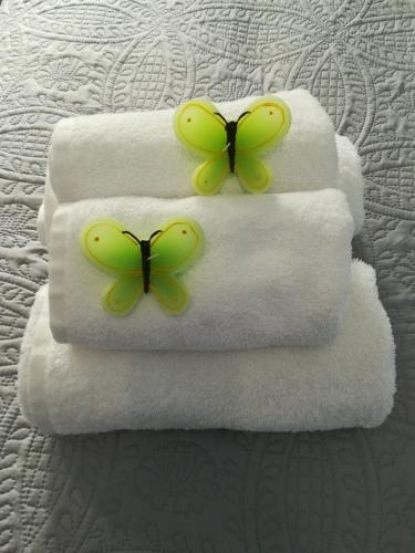 two yellow butterflies sitting on towels on a bed at Sugar Home in Xylokastro