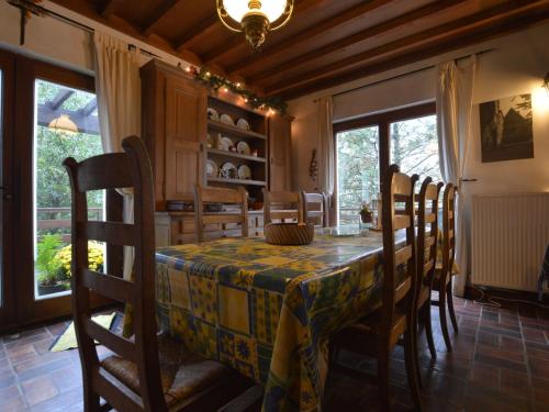 comedor con mesa y algunas sillas y ventanas en Amazing Chalet in Stavelot with Garden, en Stavelot