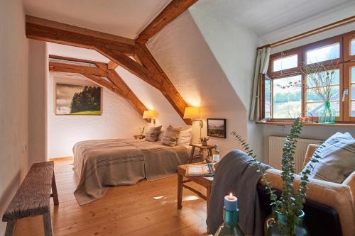a bedroom with a bed and a couch and a window at Hotel & Restaurant Linde in Münstertal