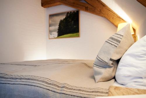 a bed with two pillows and a picture on the wall at Hotel & Restaurant Linde in Münstertal