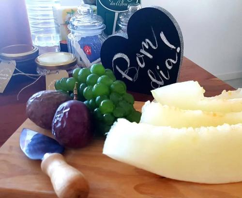 a cutting board with grapes and cheese on a table at Refúgio in Horta
