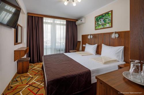 a hotel room with a bed and a table at Privetlivy bereg in Gelendzhik