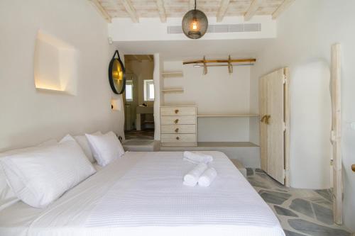 a bedroom with a large white bed with white pillows at Kostantis Summer Villas and Suites in Ornos