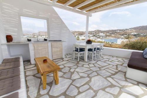 a living room with a table and a kitchen and a couch at Kostantis Summer Villas and Suites in Ornos