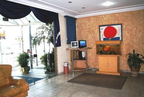 a living room with a fish tank and a couch at Hotel Capriccio São Caetano in São Caetano do Sul