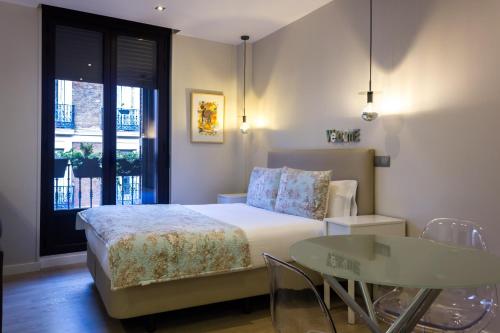 a bedroom with a bed and a glass table at Arenal Suites Preciados in Madrid