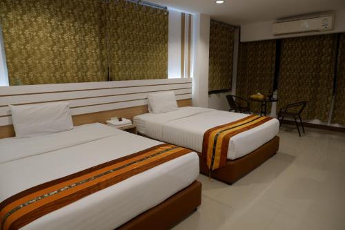 een hotelkamer met 2 bedden en een tafel bij Berich Hotel in Tak
