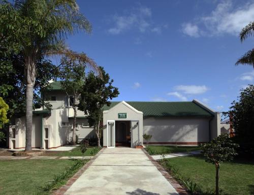 克拉格斯Elephant Country Guest House的一栋白色的房子，门前有一条车道