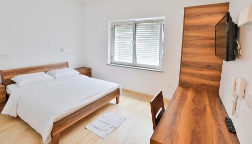 a bedroom with a bed and a window at Prenočišča Kogoj in Miren