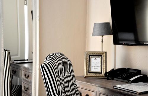 a room with a desk with a chair and a phone at Klosterhotel Neuzelle in Neuzelle