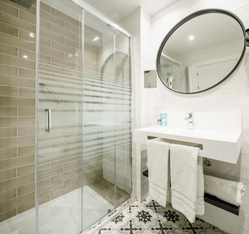 a bathroom with a shower and a sink and a mirror at Hotel Ilunion Bilbao in Bilbao