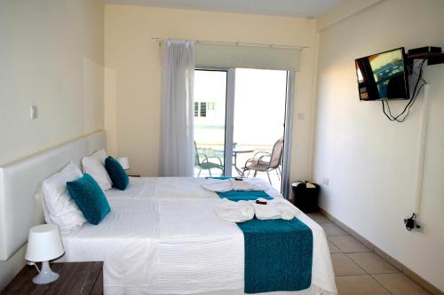 a bedroom with a large white bed with blue pillows at Cross Road in Ayia Napa