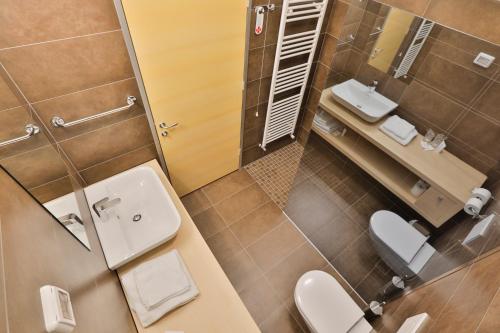 uma casa de banho com 2 WC, um lavatório e um espelho. em Prenočišča Kogoj em Miren