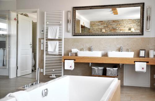 a bathroom with two sinks and a large mirror at Klosterhotel Neuzelle in Neuzelle